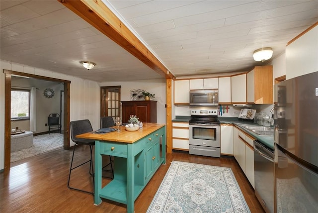 kitchen featuring white cabinets, appliances with stainless steel finishes, dark wood-type flooring, and butcher block counters