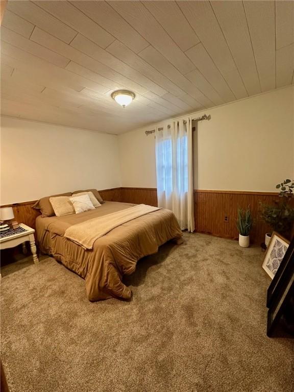 bedroom with wood walls and carpet