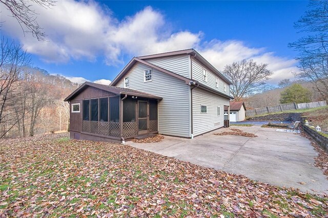 rear view of property with a patio area and a sunroom