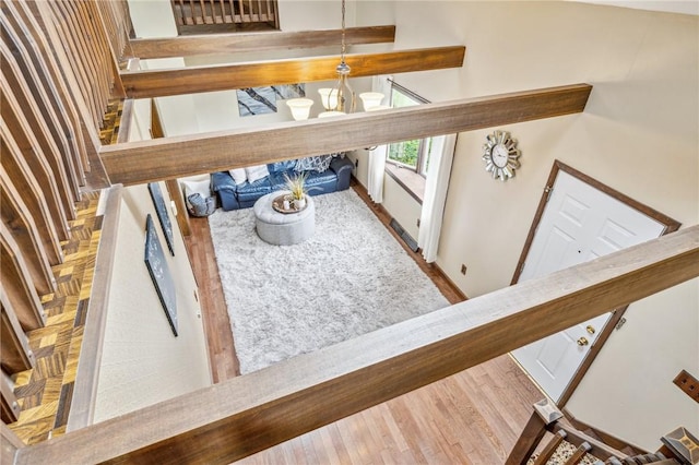 stairs with hardwood / wood-style floors and a notable chandelier