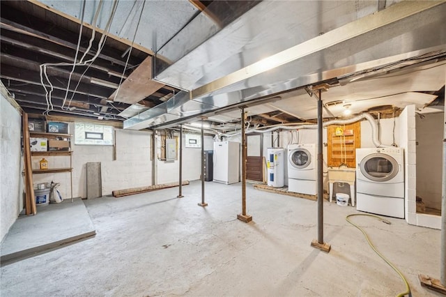 basement with electric water heater, electric panel, white refrigerator, sink, and washing machine and dryer