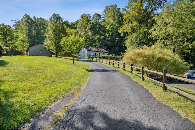 view of front of home with a front lawn and a rural view