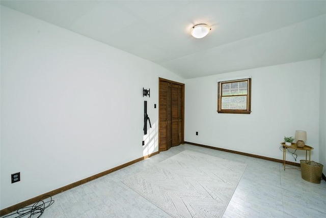 unfurnished room with lofted ceiling