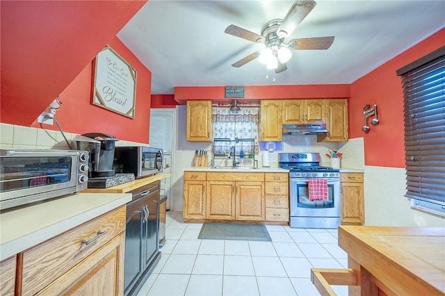 kitchen featuring appliances with stainless steel finishes, light tile patterned floors, ceiling fan, and sink