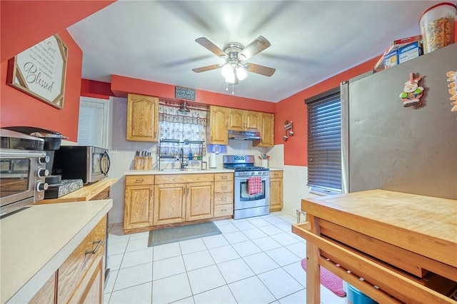 kitchen featuring light tile patterned flooring, stainless steel appliances, ceiling fan, and sink