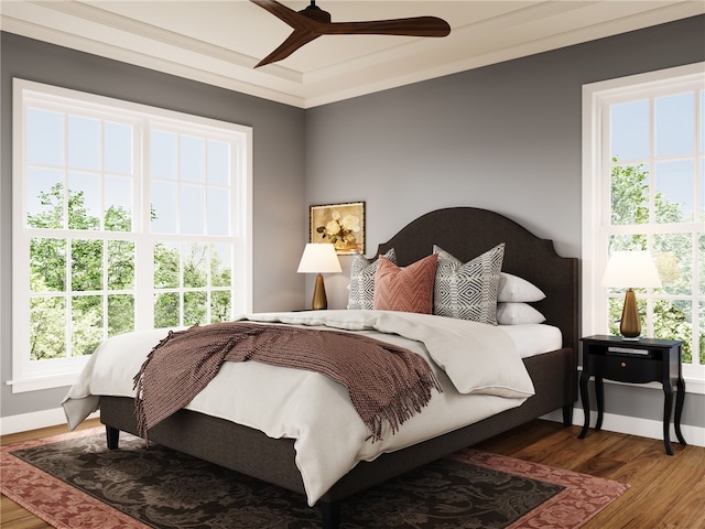 bedroom featuring hardwood / wood-style flooring, multiple windows, and ceiling fan