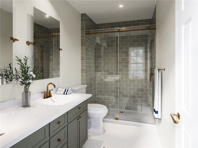 bathroom with tile patterned flooring, vanity, a shower with shower door, and toilet