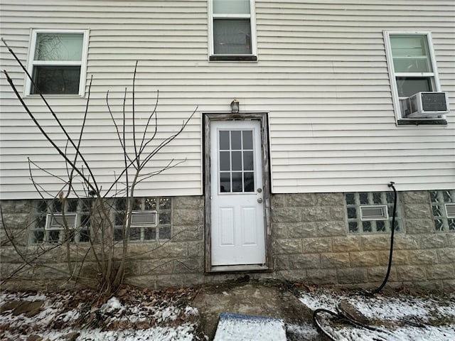 snow covered property entrance with cooling unit