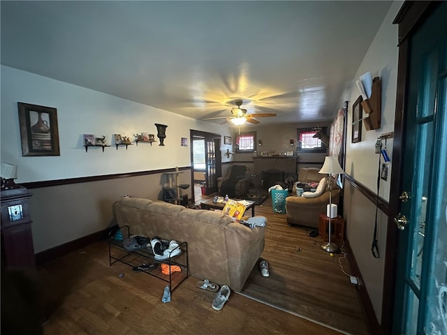 living room with a fireplace, wood-type flooring, and ceiling fan