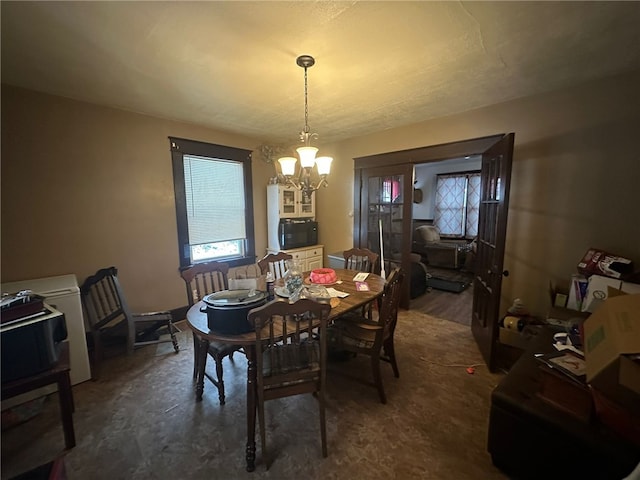 dining space with dark hardwood / wood-style flooring and an inviting chandelier