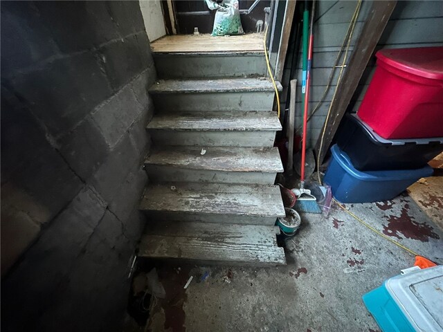 stairs featuring concrete flooring