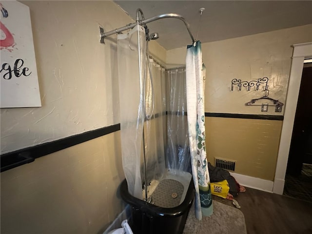 bathroom with hardwood / wood-style floors and a shower with shower curtain