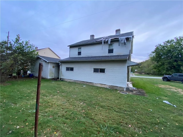 rear view of property featuring a lawn