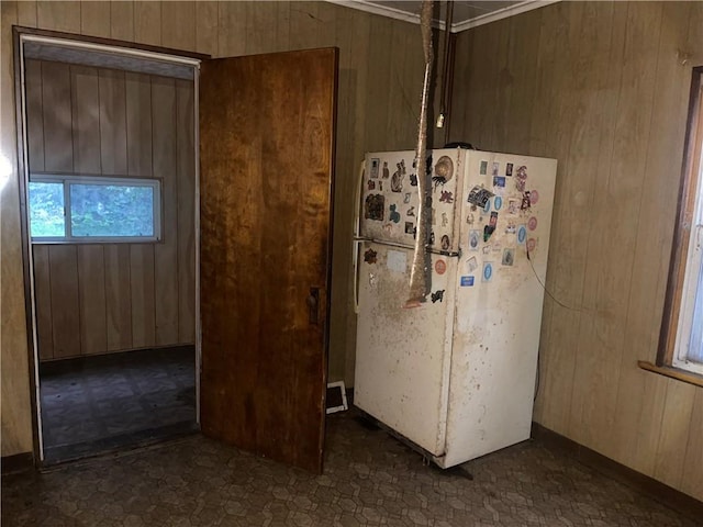 kitchen featuring white refrigerator and wood walls