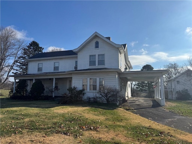 view of front facade featuring a front lawn and a carport