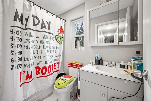 bathroom with vanity, a textured ceiling, and toilet