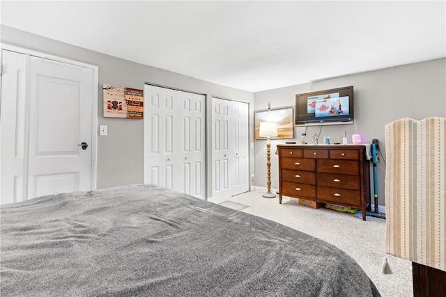 carpeted bedroom featuring multiple closets