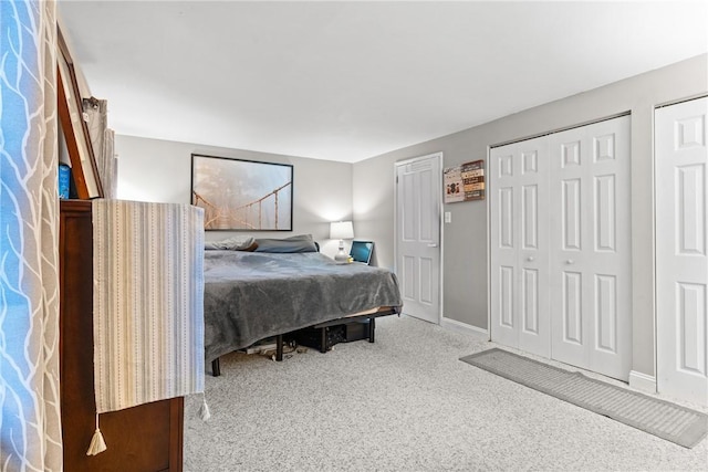 bedroom with carpet floors and two closets