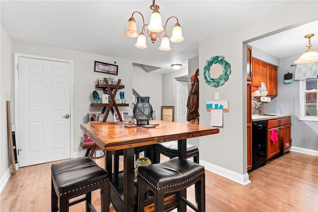 dining space with a notable chandelier and light hardwood / wood-style floors