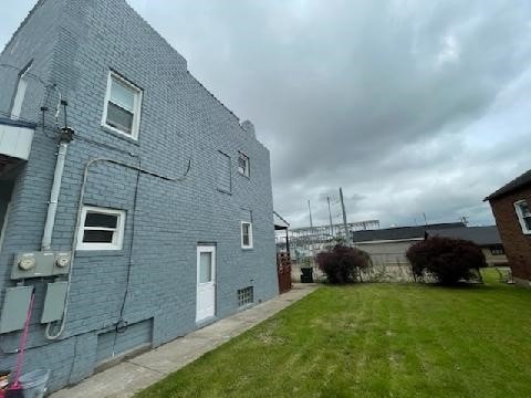 view of side of home with a yard