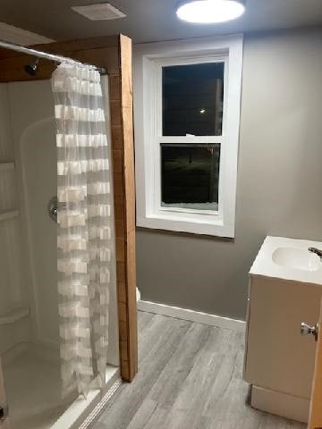 bathroom featuring hardwood / wood-style floors, a shower with shower curtain, and vanity