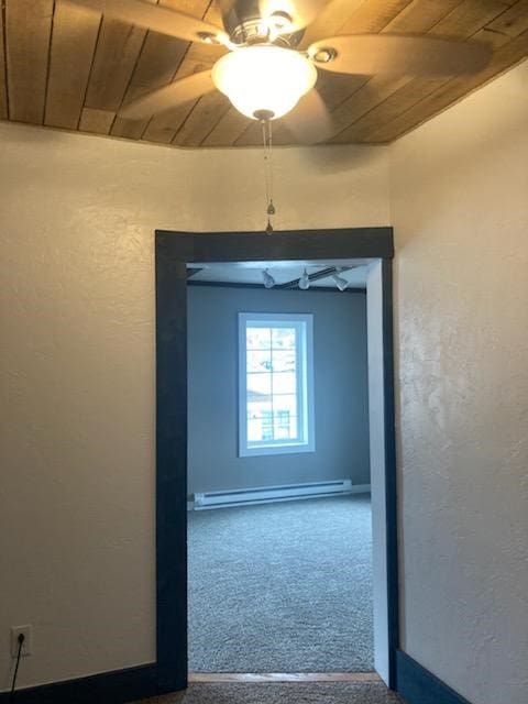 carpeted spare room featuring ceiling fan, wood ceiling, and baseboard heating