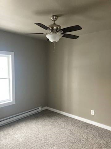 carpeted empty room with ceiling fan and baseboard heating