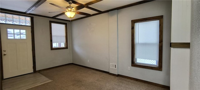 carpeted foyer with ceiling fan and beamed ceiling