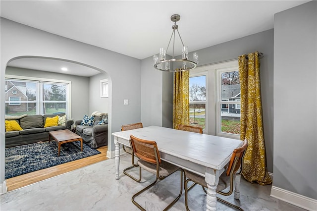 dining area with hardwood / wood-style flooring and an inviting chandelier