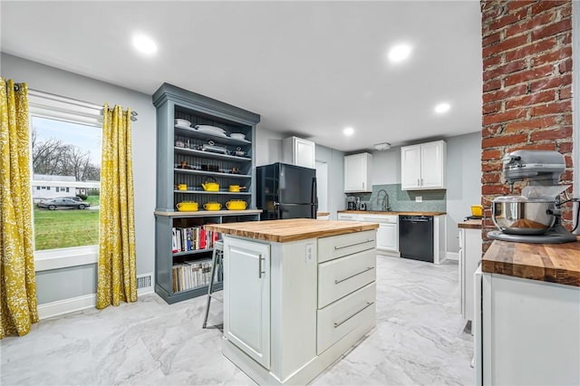 kitchen with black appliances, white cabinets, wooden counters, and a kitchen island