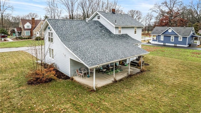 rear view of house with a lawn and a patio