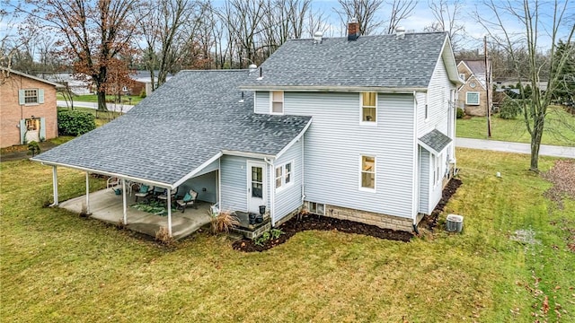 rear view of house featuring a lawn and a patio area