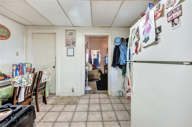 interior space with white fridge and a drop ceiling