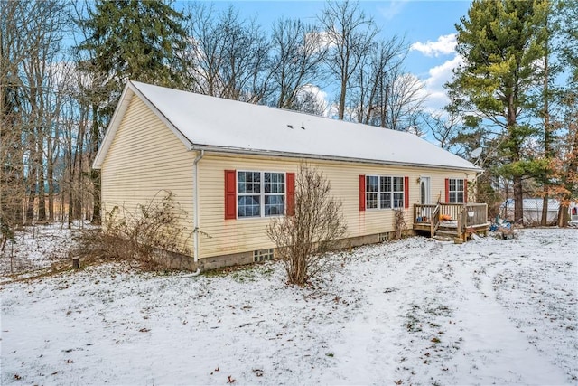 snow covered house featuring a deck