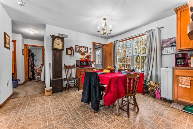 carpeted dining area featuring a notable chandelier