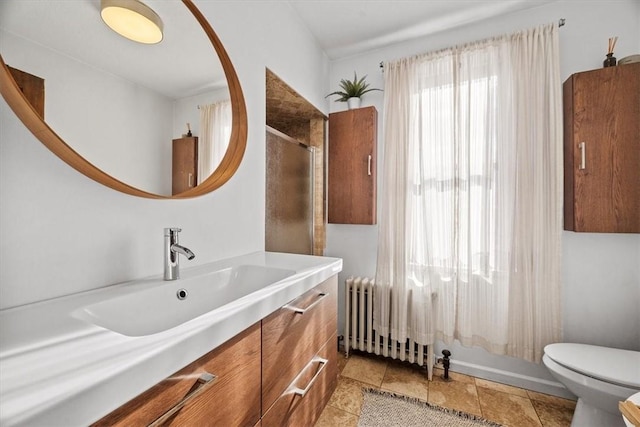 bathroom with radiator heating unit, vanity, and toilet