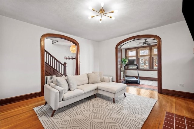 living room featuring a chandelier, a textured ceiling, and light hardwood / wood-style flooring