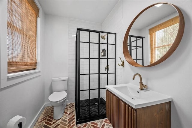 bathroom with vanity, a shower with shower door, and toilet