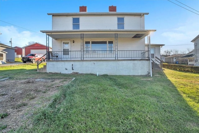 rear view of property featuring a yard, an outbuilding, a porch, and a garage