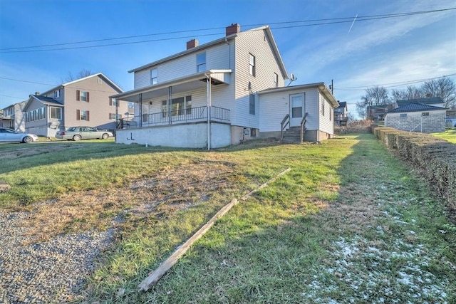 rear view of property with a yard and covered porch