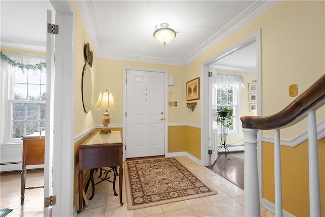 foyer entrance featuring light wood-type flooring, crown molding, and a baseboard radiator