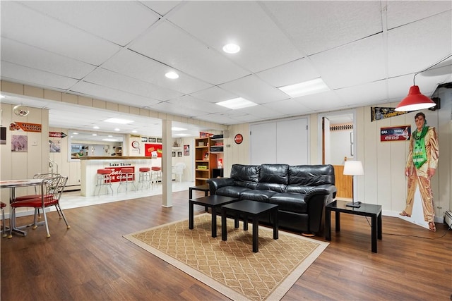 living room featuring hardwood / wood-style flooring, indoor bar, and a paneled ceiling