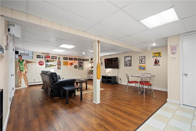 recreation room featuring hardwood / wood-style flooring, a baseboard radiator, and a drop ceiling