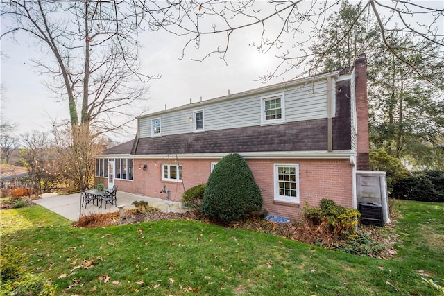 back of property with a lawn, central AC unit, and a patio area