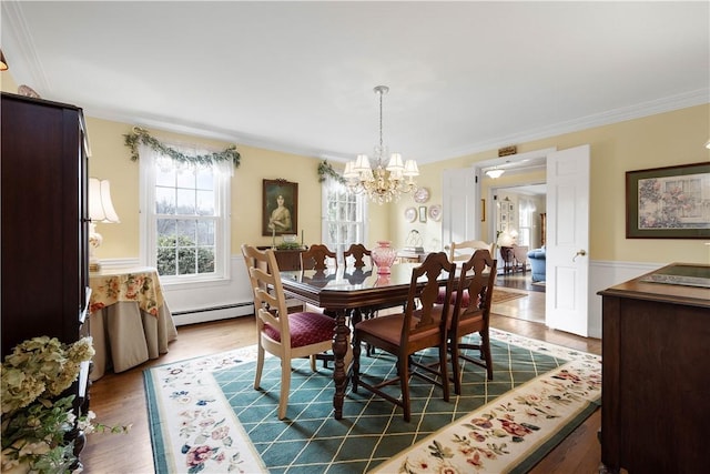 dining room featuring a notable chandelier, dark hardwood / wood-style flooring, crown molding, and a baseboard heating unit