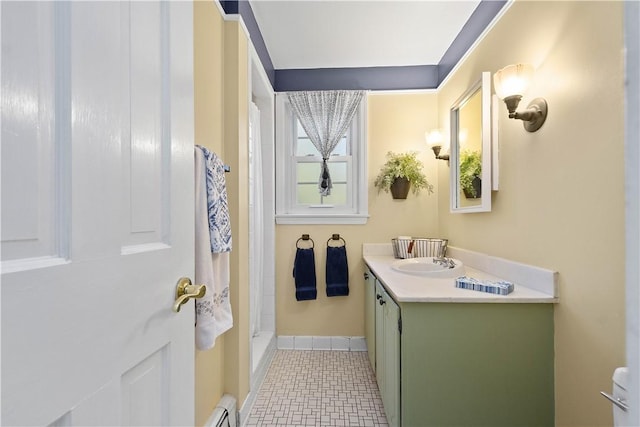 bathroom featuring a shower, vanity, and baseboard heating