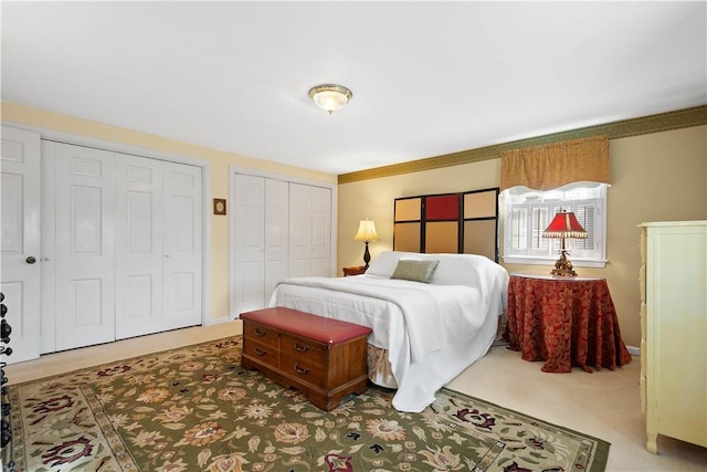 bedroom with multiple closets and carpet flooring