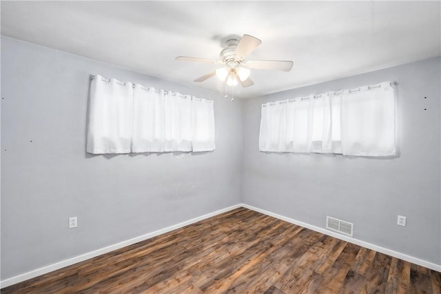 empty room with ceiling fan and dark hardwood / wood-style floors