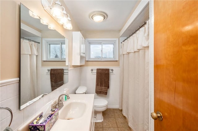 bathroom with tile patterned flooring, vanity, tile walls, and toilet