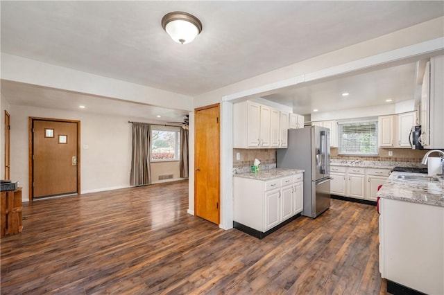 kitchen featuring white cabinetry, dark hardwood / wood-style flooring, plenty of natural light, and appliances with stainless steel finishes